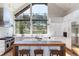 Bright kitchen features stainless appliances, white cabinetry, large island, and a large window with backyard views at 2250 Highlands Dr, Breckenridge, CO 80424