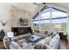 Open living room with stone fireplace, vaulted ceiling, mountain views and comfortable seating at 2250 Highlands Dr, Breckenridge, CO 80424