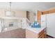 Open concept kitchen featuring a breakfast bar, white appliances, and a view into the living room at 9960 Kline St, Broomfield, CO 80021