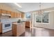 Well-lit kitchen featuring an island, light wood cabinets, and modern appliances at 9960 Kline St, Broomfield, CO 80021