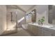 Bathroom featuring a walk-in shower with tile surround, soaking tub, double vanity and a large mirror at 1227 N Ford St, Golden, CO 80403