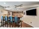 Finished basement featuring a wet bar with stone accent wall, wooden countertop, and bar stool seating at 26530 E Euclid Pl, Aurora, CO 80016