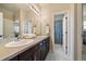 Bathroom with double sinks, dark wood cabinetry, and a separate toilet room at 26530 E Euclid Pl, Aurora, CO 80016