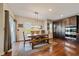 Dining room with wood table, bench seating, modern lighting, and built-in cabinets with stainless steel appliances at 26530 E Euclid Pl, Aurora, CO 80016