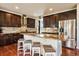 Kitchen with island, granite countertops, stainless appliances, dark wood cabinets, and tile backsplash at 26530 E Euclid Pl, Aurora, CO 80016