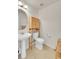 This bathroom offers a pedestal sink, a modern toilet, and stylish storage shelves for towels at 13457 Locust St, Thornton, CO 80602