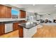 Open kitchen with a dark countertop island, stainless steel appliances, and hardwood floors at 13457 Locust St, Thornton, CO 80602