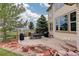 Lush backyard with an outdoor dining area and stone waterfall, ideal for relaxation and entertaining at 10253 Fairgate Way, Highlands Ranch, CO 80126