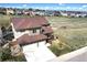 Two story home with a three car garage, brown roof, and tan and stone exterior at 10253 Fairgate Way, Highlands Ranch, CO 80126