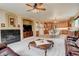 Open-concept living room boasts a fireplace, plush carpet, and seamless flow to the modern kitchen at 10253 Fairgate Way, Highlands Ranch, CO 80126
