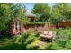 Private backyard with brick patio and lush garden featuring a lovely bench at 2215 E 7Th Avenue Pkwy, Denver, CO 80206