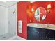 Bathroom featuring a glass shower, red walls, and black vanity with marble top and round mirror at 2215 E 7Th Avenue Pkwy, Denver, CO 80206
