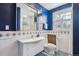 Stylish blue bathroom with white tiles, modern fixtures, decorative accents, and ample natural light at 2215 E 7Th Avenue Pkwy, Denver, CO 80206