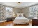 Bright bedroom featuring hardwood floors, patterned wallpaper, and white-painted window frames at 2215 E 7Th Avenue Pkwy, Denver, CO 80206