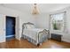 Bright bedroom features a brass bed, hardwood floors, large window, and a view of the outside at 2215 E 7Th Avenue Pkwy, Denver, CO 80206