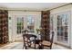 Bright dining area with glass table and chairs next to french doors and patterned window treatments at 2215 E 7Th Avenue Pkwy, Denver, CO 80206