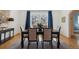 Traditional dining room with a dark wood table, seating for six, blue curtains, and hardwood floors at 2215 E 7Th Avenue Pkwy, Denver, CO 80206