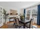 Elegant dining area featuring a black table, neutral chairs, hardwood floors, and bright blue curtains at 2215 E 7Th Avenue Pkwy, Denver, CO 80206