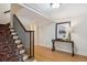 Inviting entryway with wooden floors, staircase with black wrought iron, and console table with decor at 2215 E 7Th Avenue Pkwy, Denver, CO 80206