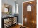 Inviting foyer features a wood door with glass inset, decorative mirrored console table, and beautiful hardwood floors at 2215 E 7Th Avenue Pkwy, Denver, CO 80206