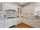 Well-lit kitchen boasts white cabinets, granite countertops, subway tile backsplash, and stainless steel appliances at 2215 E 7Th Avenue Pkwy, Denver, CO 80206