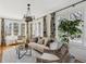Bright living room with many windows, neutral furniture, large plant, and stylish chandelier and curtains at 2215 E 7Th Avenue Pkwy, Denver, CO 80206