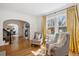 Bright living room showcasing hardwood floors, archways, and windows with elegant yellow curtains at 2215 E 7Th Avenue Pkwy, Denver, CO 80206