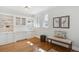 Well-lit home office features built-in shelving, a comfortable bench, hardwood floors, and large windows at 2215 E 7Th Avenue Pkwy, Denver, CO 80206