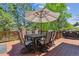 Outdoor deck with shaded dining table and chairs, with beautiful leafy scenery at 9880 E Progress Cir, Greenwood Village, CO 80111
