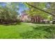 Expansive backyard with lush green lawn, mature trees, and a patio at 9880 E Progress Cir, Greenwood Village, CO 80111