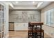 Basement bar boasts unique tiling, glass shelving, cabinetry, mini fridge and bar stool seating at 9880 E Progress Cir, Greenwood Village, CO 80111