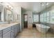 Bathroom featuring a double vanity, free standing tub, and glass enclosed shower at 9880 E Progress Cir, Greenwood Village, CO 80111