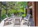 Backyard patio features rocking chairs encircling a stone fire pit, surrounded by greenery at 9880 E Progress Cir, Greenwood Village, CO 80111