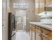 Functional laundry room features wood cabinets, sink, and modern washer and dryer at 9880 E Progress Cir, Greenwood Village, CO 80111