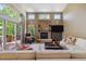 Cozy living room with a stone fireplace, large windows, and access to a deck at 9880 E Progress Cir, Greenwood Village, CO 80111