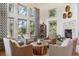 Bright living room with high ceilings, multiple windows, comfortable seating, and a cozy fireplace at 9880 E Progress Cir, Greenwood Village, CO 80111