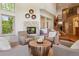 Bright living room featuring a fireplace, comfortable seating, views of the staircase, and high ceilings at 9880 E Progress Cir, Greenwood Village, CO 80111