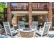Outdoor patio featuring white rocking chairs around a stone fire pit at 9880 E Progress Cir, Greenwood Village, CO 80111