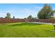 Expansive grassy backyard has a concrete pad and a wooden perimeter fence at 11192 E 7Th Ave, Aurora, CO 80010