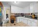 Functional kitchen featuring tiled floors, classic white cabinets, and essential appliances at 11192 E 7Th Ave, Aurora, CO 80010