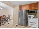Efficient kitchen with stainless steel refrigerator, white range, and tile floors leading to dining area at 11192 E 7Th Ave, Aurora, CO 80010