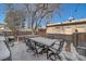 Backyard with snowy patio, outdoor dining set, hot tub, and grill, ideal for winter entertaining at 3323 W Hayward Pl, Denver, CO 80211