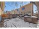 Winter backyard featuring a snowy patio, dining set, hot tub, and grill, great for year-round outdoor enjoyment at 3323 W Hayward Pl, Denver, CO 80211
