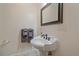 Charming powder room featuring a pedestal sink, decorative mirror, and neutral color scheme at 3323 W Hayward Pl, Denver, CO 80211
