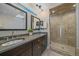 Bright bathroom featuring a double sink vanity, large tub, and glass shower at 3323 W Hayward Pl, Denver, CO 80211