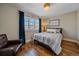Comfortable bedroom features hardwood floors and large window at 3323 W Hayward Pl, Denver, CO 80211