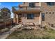 Inviting home featuring stone accents, a cozy front patio setup, and a balcony, perfect for enjoying the outdoors at 3323 W Hayward Pl, Denver, CO 80211