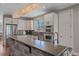 Modern kitchen featuring stainless steel appliances, stone counter and elegant lighting at 3323 W Hayward Pl, Denver, CO 80211