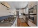 Spacious modern kitchen featuring stainless appliances, stone details, and hardwood floors at 3323 W Hayward Pl, Denver, CO 80211