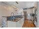Bright modern kitchen with stone-accented island, stainless steel appliances, and open layout at 3323 W Hayward Pl, Denver, CO 80211